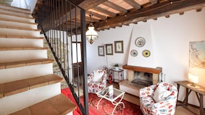 A staircase with a stone wall, a fireplace, and a red patterned rug. - Gorgeous apartment in Frazione Canonica,Todi (Frazione Canonica,Todi)
