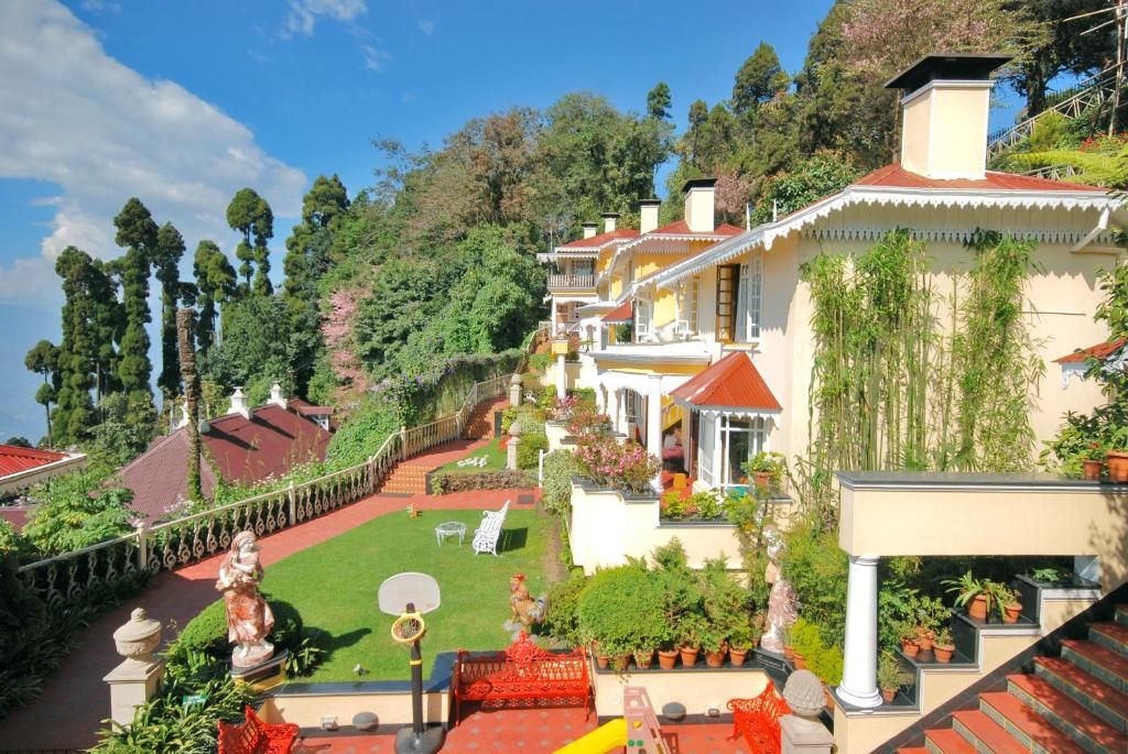 A hillside property with terraced gardens, a basketball court, and a variety of potted plants.