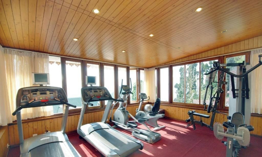 A gym with treadmills, elliptical machines, and weight equipment.