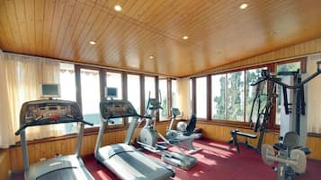 A gym with treadmills, elliptical machines, and weight equipment.