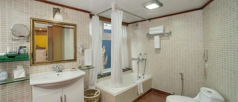 A bathroom with a sink, mirror, toilet, shower, and bathtub.