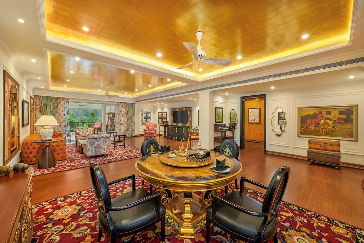 A spacious room with a round table, chairs, and a ceiling fan.