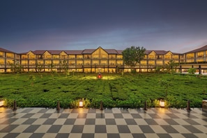 A hotel with a courtyard featuring a checkered floor and a tea garden. - Mayfair Tea Resort Siliguri (Siliguri)