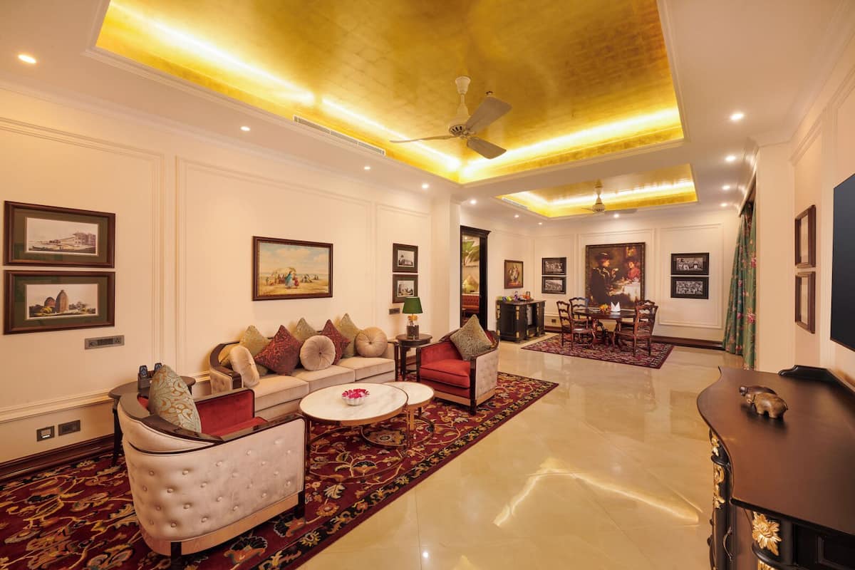 A spacious living room with a sofa set, a coffee table, and a dining area with chairs and a table.