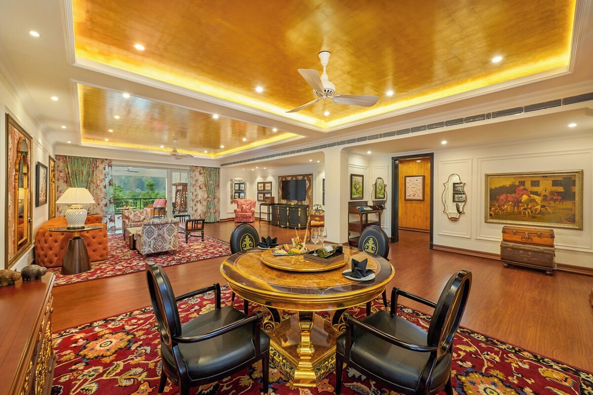 A spacious room with a round table, chairs, and a ceiling fan.