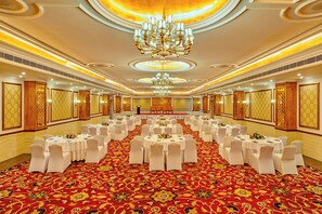 A banquet hall with round tables, white chairs, and a red carpet. - Mayfair Tea Resort Siliguri (Siliguri)