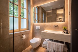 Un bagno moderno con servizi igienici, lavabo e doccia.