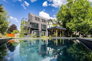 A modern house with a swimming pool, large windows, and a covered outdoor area. - Sunrose 7 Heritage Boutique Hotel (Bohinj)