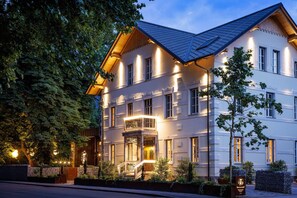 Un hotel dal design architettonico classico, con un ingresso caratteristico che include un cancello e un balcone.