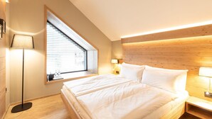 A bedroom with a bed, a window, a lamp, and a wooden headboard. - Sunrose 7 - Heritage Boutique Hotel - Adults Only (Bohinj)