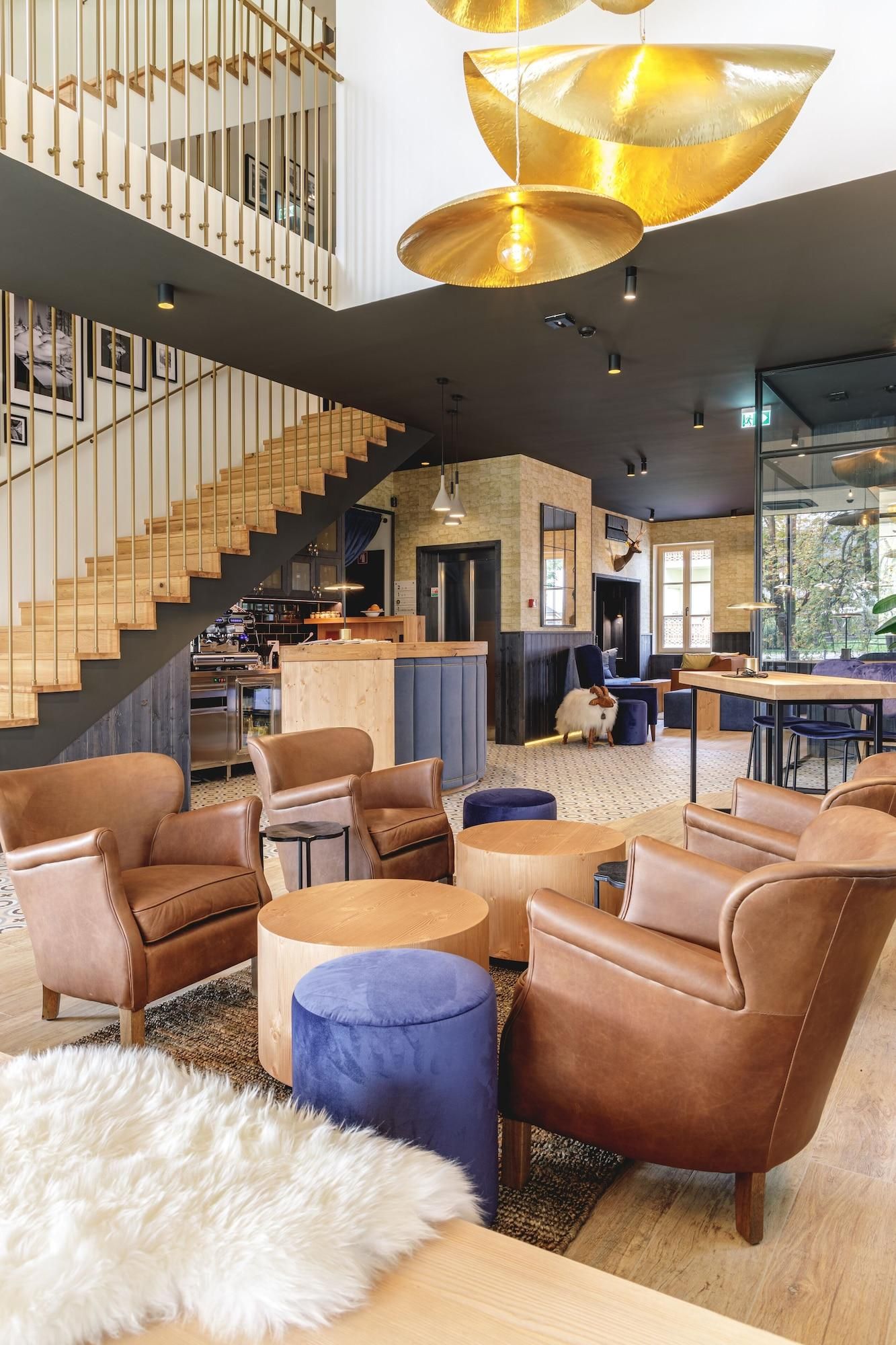 Un interior espacioso con una escalera, asientos de cuero y una lámpara moderna.