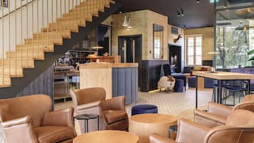 A spacious interior with a staircase, leather seating, and a modern chandelier.