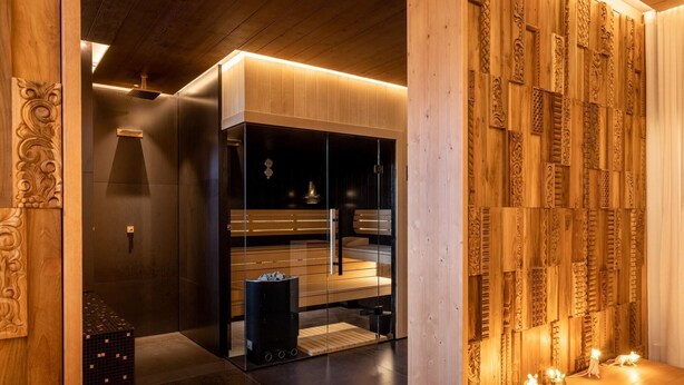 A modern spa room with a sauna, wooden paneling, and a small table with candles. - Sunrose 7 - Heritage Boutique Hotel - Adults Only (Bohinj)
