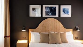A hotel room with a wooden headboard, white bedding, and three framed pictures on the wall.
