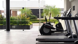 Ein Fitnessstudio mit Laufbändern und einem FlexDeck Stoßabsorbationssystem, großen Fenstern sowie Blick auf ein Gebäude und Grünflächen.