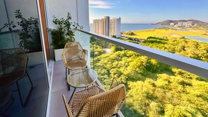 A balcony with wicker furniture and a view of a coastal landscape. - Suite Vista A Reserva y Mar Piso Alto En Bello Horizonte (Santa Marta)