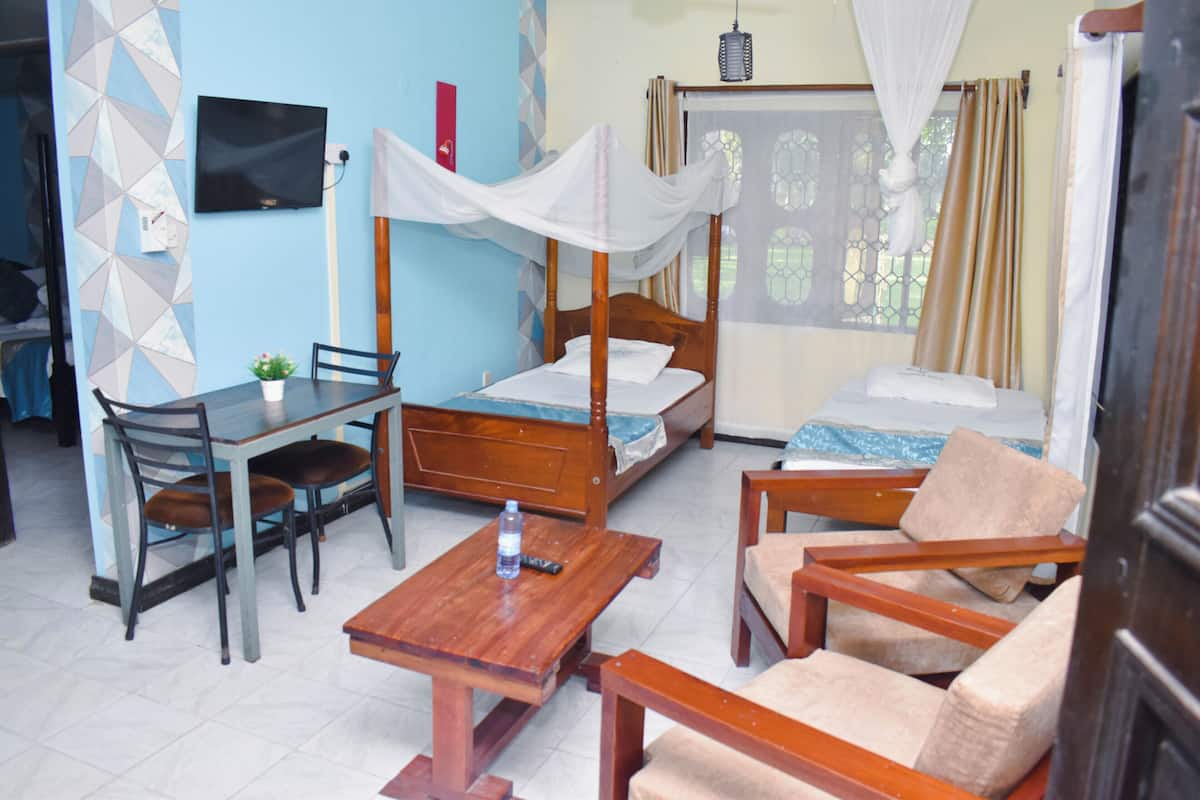 Una habitación con cama, escritorio, silla y sofá.