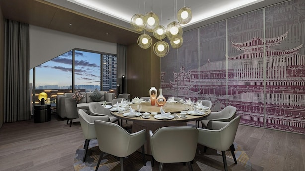 A modern dining room with a round table set for six, surrounded by grey chairs. - Dhawa Xi'an Chanba (Xi'an)