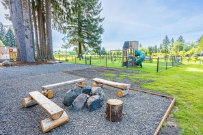 A playground with a slide, swings, and a fenced area.