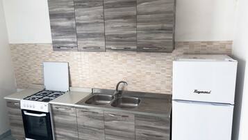 Frigorífico, horno, utensilios de cocina y mesa de comedor