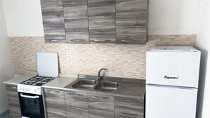 Frigorífico, horno, utensilios de cocina y mesa de comedor