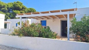 Un bâtiment moderne à l’extérieur blanc, doté d’un porche abrité et d’une porte.