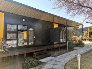 A modern building with large windows, a covered outdoor area, and a paved walkway. - Sleepover Kruger Gate (Mbombela)