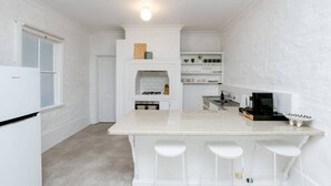 A compact kitchen with a central island, white cabinetry, and a built-in oven.