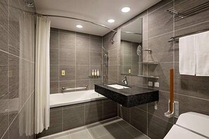 Une salle de bain moderne avec une baignoire, un lavabo et un miroir.