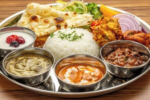 A traditional Indian meal with rice, various curries, and naan bread on a metal plate. - Hotel Unizo Kyoto Karasuma Oike (Kyoto)