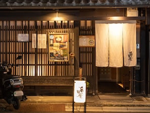 A restaurant entrance with a signboard, a motorcycle parked outside, and traditional Japanese decor. - Hotel Unizo Kyoto Karasuma Oike (Kyoto)