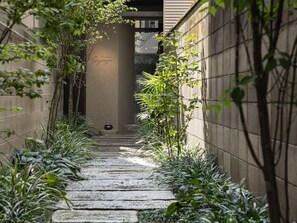 A narrow stone pathway flanked by greenery and a building facade. - Hotel Unizo Kyoto Karasuma Oike (Kyoto)
