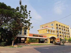 A hotel with a yellow facade, a sign reading "Grand Smile," and a "Health" sign. - Grandsmile Welnez Condo Pattaya (Pattaya)