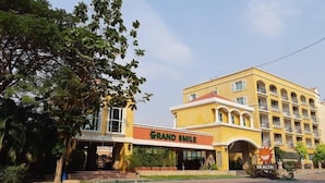Ein Hotel mit gelber Fassade, einer Beschilderung mit dem Schriftzug "Grand Smile" und einem Schild mit der Aufschrift "Gesundheit".