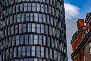 Ein modernes Gebäude mit einer geschwungenen Fassade und großen Fenstern.