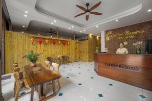 Un'area reception con arredamento a tema bambù, che include una scrivania reception con la scritta "Golden Bamboo Villa & Spa".