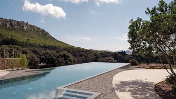 Una piscina amb una vista clara del paisatge circumdant, incloent arbres i turons.