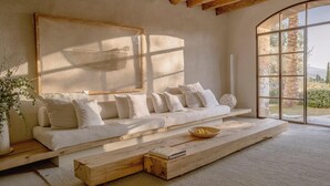 A modern living room with a sofa, a woven basket, and a wooden coffee table. - Es Racó D Artá (Arta)