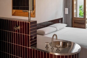 A modern bathroom with a built-in sink, a mirror, and a wooden panel design. - Hotel Humano (Santa María Colotepec)