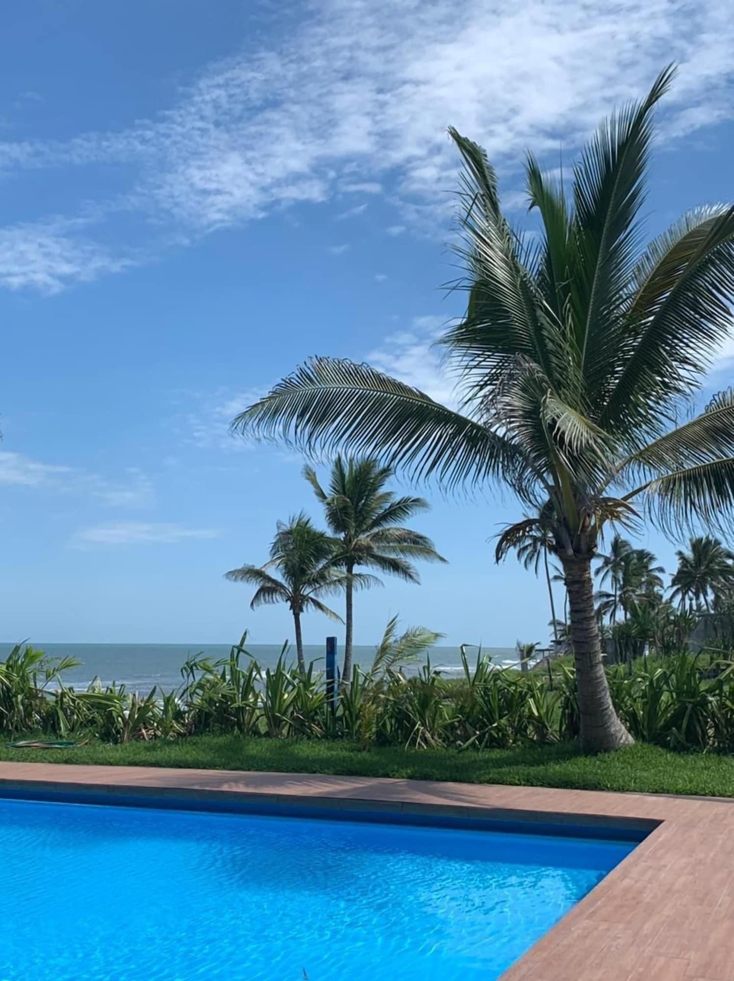 Una piscina con vistas al océano y palmeras.