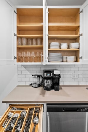 A kitchen with white cabinets, a coffee maker, and a dishwasher. - Expansive 4BD - Steps from downtown - Oak Park (Oak Park)