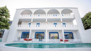 A white building with a pool in front. - Collection O To The Sea Resort Thailand (Sattahip)
