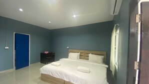 A bedroom with a bed, a blue door, a nightstand, and an air conditioning unit. - Collection O To The Sea Resort Thailand (Sattahip)
