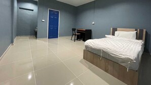 A bedroom with a bed, a desk, and a chair. - Collection O To The Sea Resort Thailand (Sattahip)