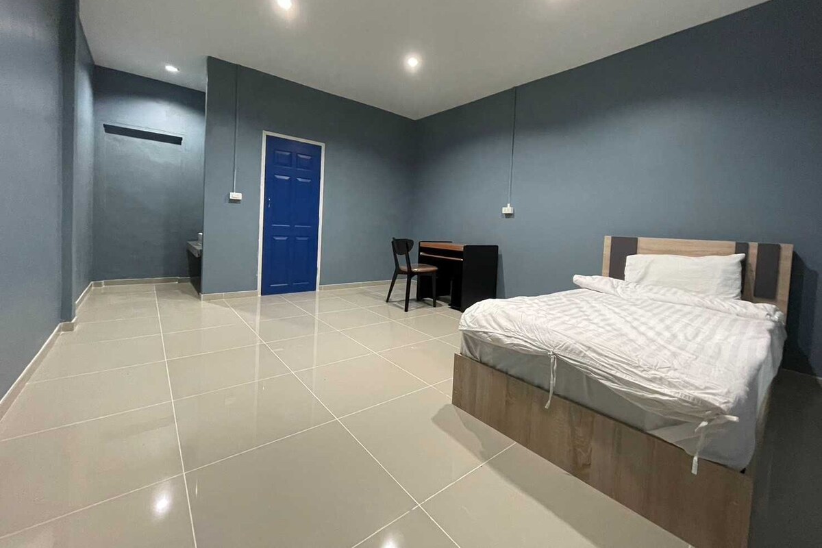 Un dormitorio con una cama, un escritorio y una silla.