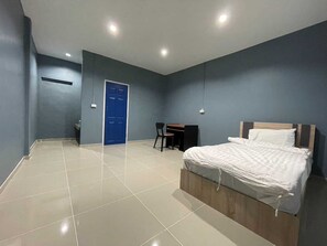 Un dormitorio con una cama, un escritorio y una silla.