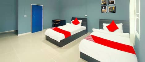 Una habitación de hotel con dos camas, una puerta azul y una pequeña mesa.