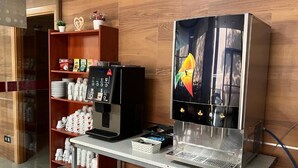 A coffee machine and a refrigerator in a room with wooden walls and a shelf with cups and plates. - B&b Hotel Tarragona Reus  (Reus)