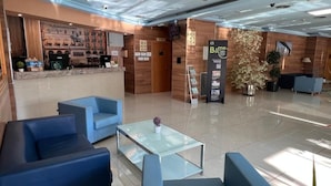 A modern hotel lobby with blue seating, a reception desk, and a large potted plant. - B&b Hotel Tarragona Reus  (Reus)
