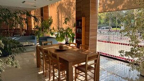 A modern dining area with a wooden table and chairs, surrounded by large windows and indoor plants. - B&b Hotel Tarragona Reus  (Reus)